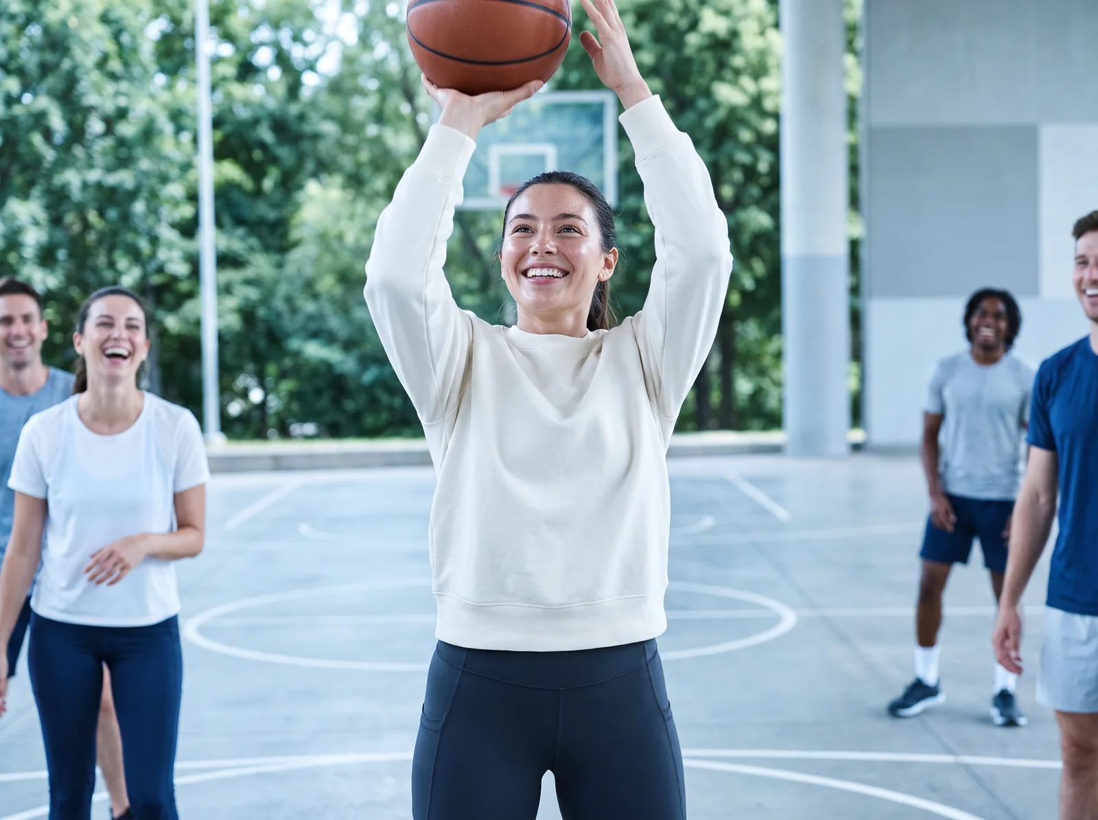 A woman playing basketball on an outdoor court