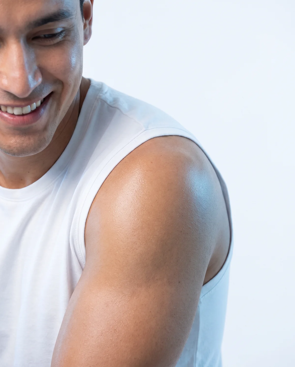 Close-up of a man's shoulder and arm in a white sleeveless tee